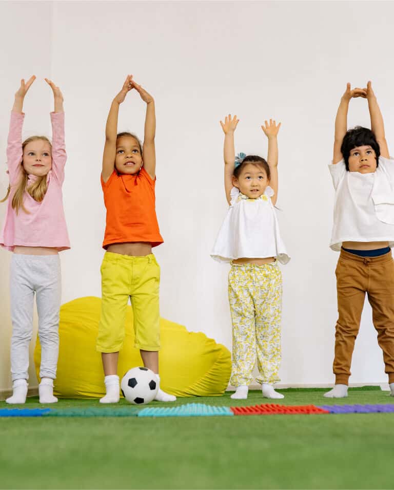 Niños realizando actividad física y ejercicios de movimiento en un entorno educativo infantil