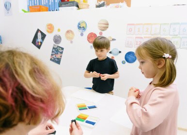 Niños realizando una actividad educativa con materiales didácticos que estimulan la concentración y el pensamiento lógico