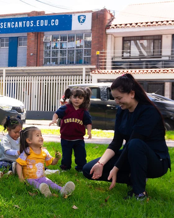 Educadora infantil de Pequeños Encantos guiando a niños durante una actividad al aire libre