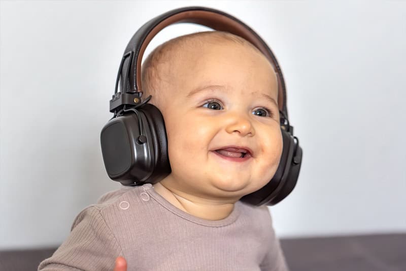 Bebé escuchando música con audífonos, estimulando el desarrollo sensorial y emocional