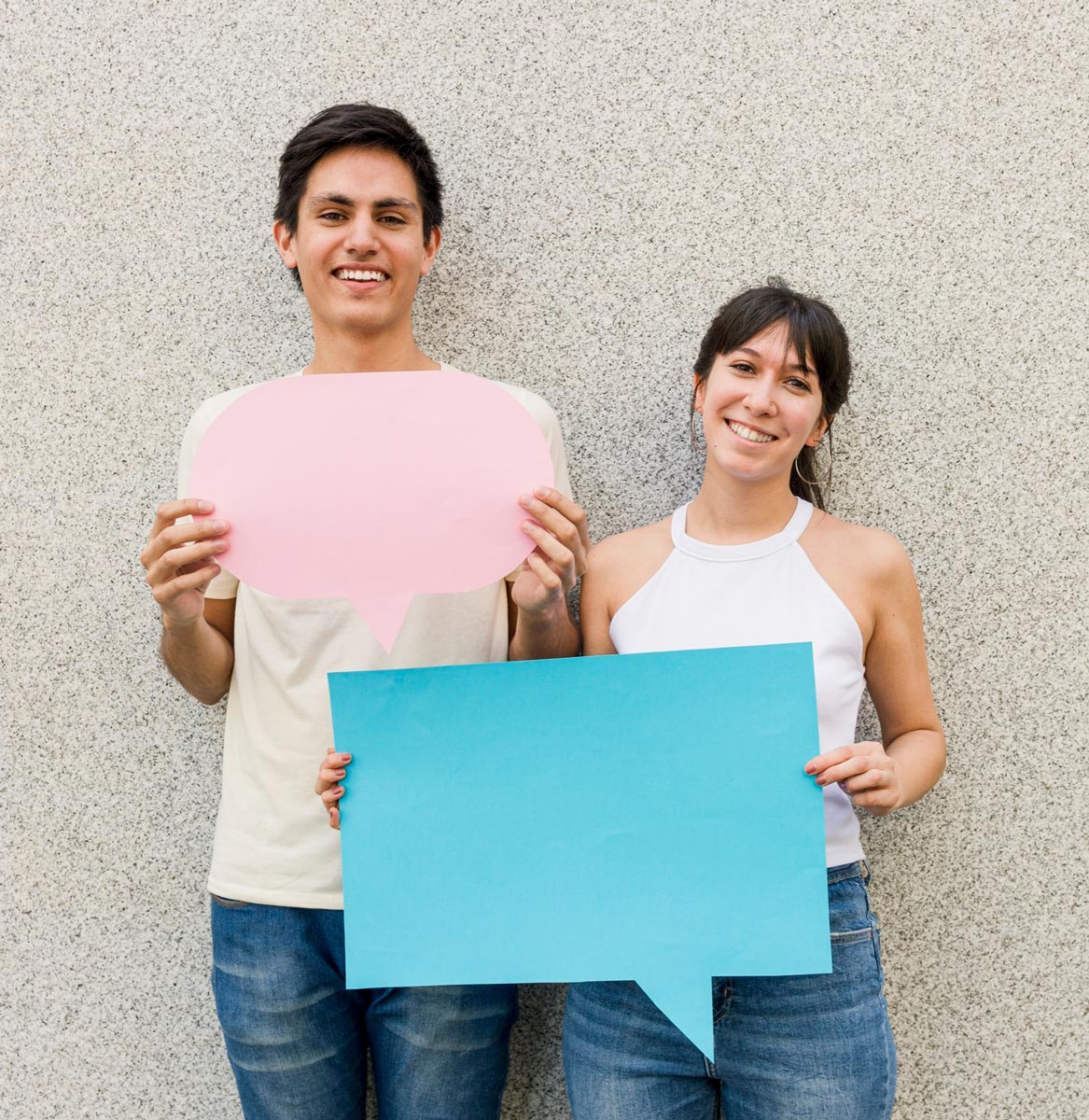 Madre y padre sonrientes sosteniendo carteles de diálogo como símbolo de testimonio y confianza en la comunidad educativa