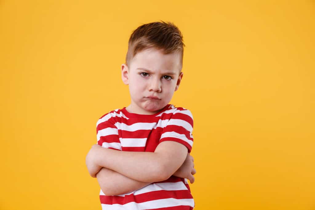 Niño con expresión de enojo o insatisfacción, mostrando actitud desafiante y malhumorada.