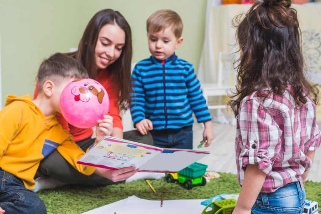Niños y maestra en actividades educativas en jardín infantil Pequeños Encantos, cuidado y aprendizaje infantil.